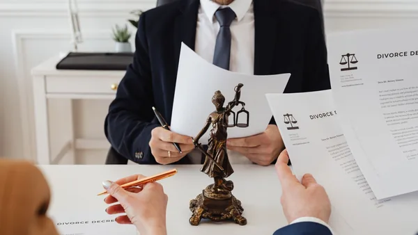 Advogado e clientes assinando documentos sobre a mesa do escritório