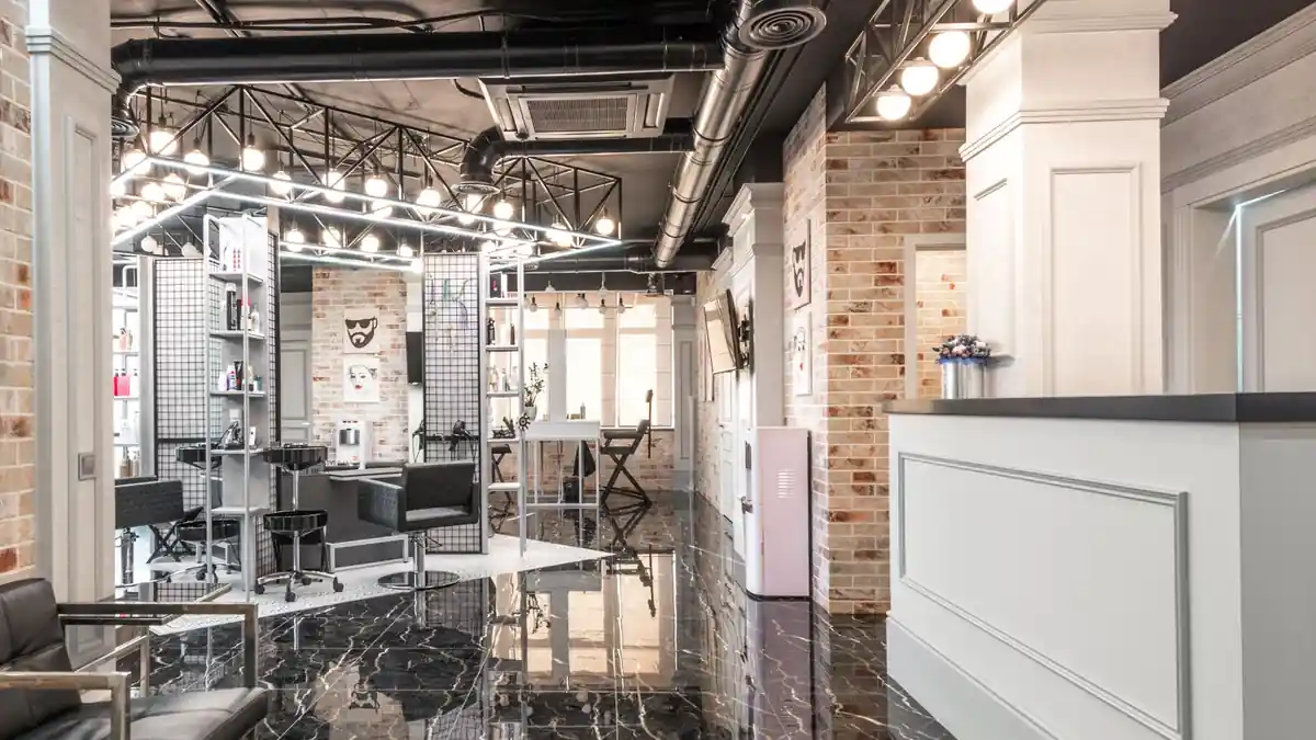 Interior de um salão de beleza, com as cadeiras, os espelhos e o balcão de recepção