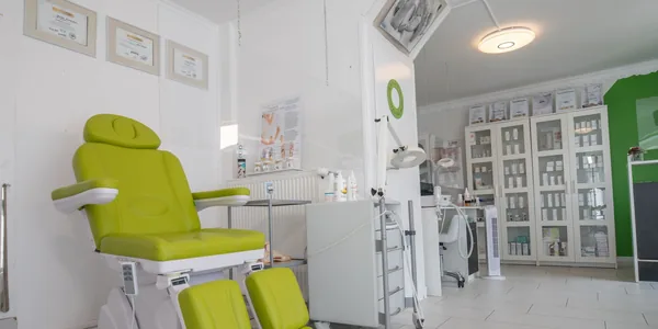 Sala de clínica com maca de tratamento e aparelhos organizados
