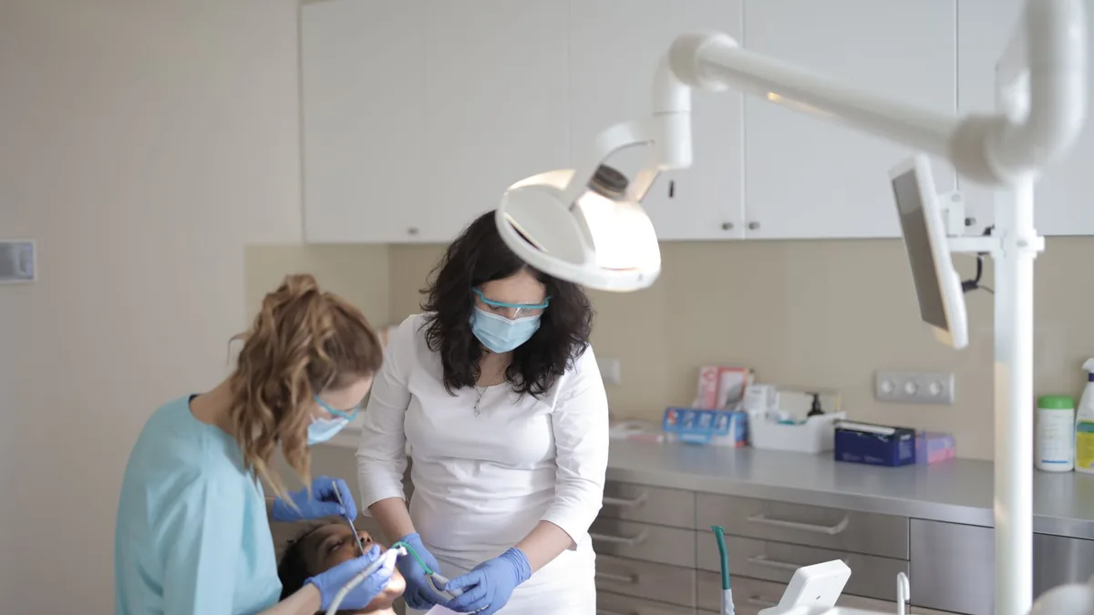 Duas dentistas fazendo um exame em uma paciente na clínica