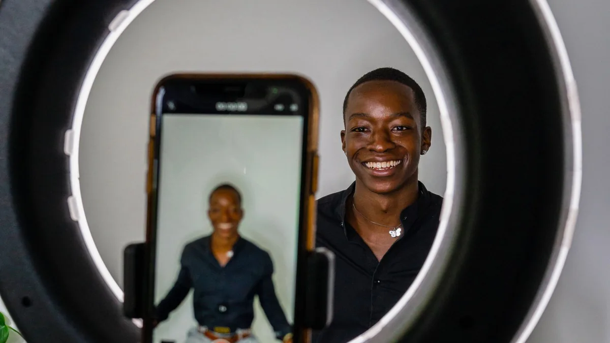 Criador de conteúdo gravando um vídeo com o celular e luz de anel