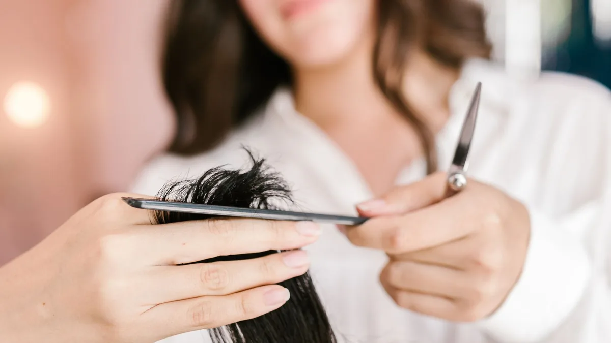 Cabeleireira cortando o cabelo de uma cliente no salão
