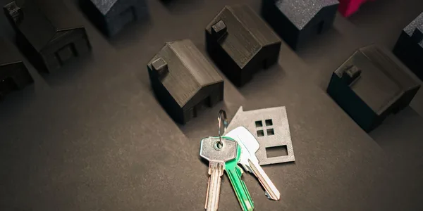 Miniaturas de casas e chaves sobre a mesa representando a tributação de aluguel de imóveis na Reforma Tributária