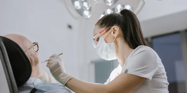 Dentista atendendo paciente em consultório odontológico moderno, ilustrando a Reforma Tributária para clínicas