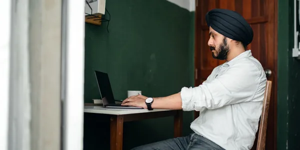 Homem trabalhando sozinho no notebook em uma mesa