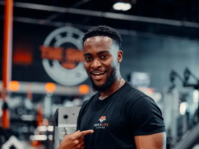 Personal trainer sorrindo dentro de academia