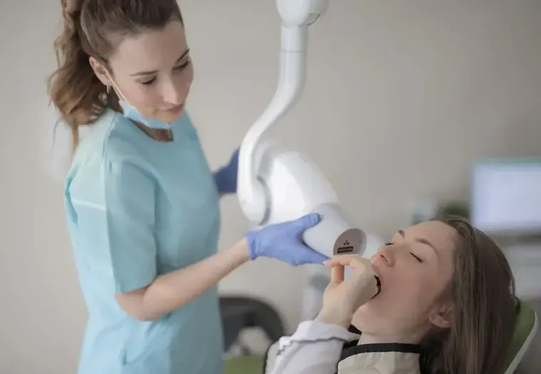 Dentista atendendo uma paciente em consult&oacute;rio odontol&oacute;gico